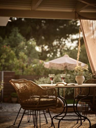 a table and chairs with wine glasses on a patio at La Maison Du Maire - Luxury Villa with Private Pool, by ZanteWize in Sarakinádhon