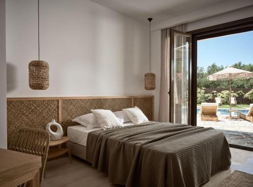 a bedroom with a bed and a large window at La Maison Du Maire Luxury Villa in Sarakinádhon