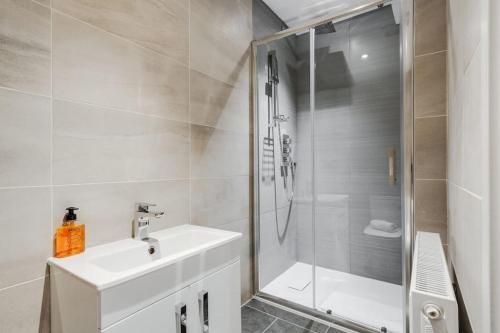 a white bathroom with a shower and a sink at Victoria Stay - Parking Wi-Fi Amazing in Hyde