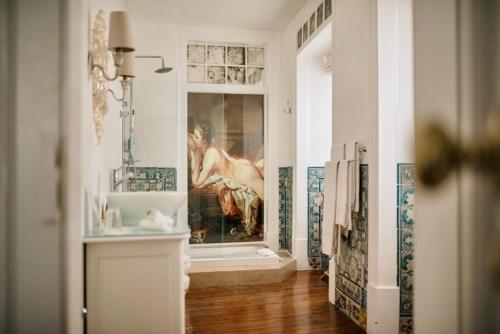 a bathroom with a painting of a woman in a bath tub at Palacio Ramalhete in Lisbon