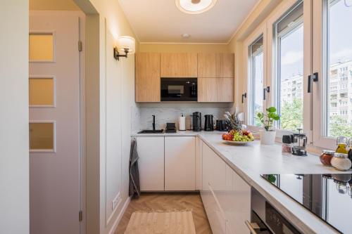 eine Küche mit weißen Schränken und einer Arbeitsplatte in der Unterkunft Stock Room apartman in Budapest