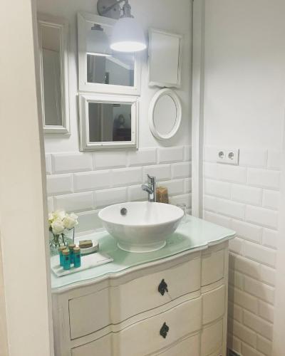 a white bathroom with a sink and a mirror at Palacio Ramalhete in Lisbon