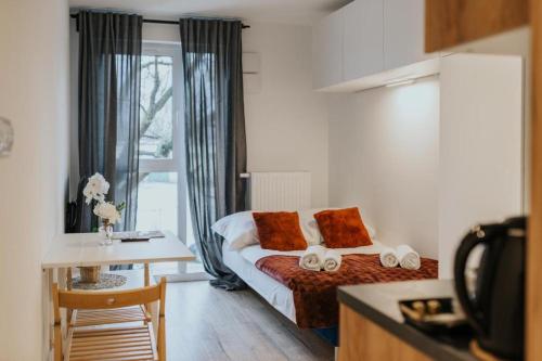 a hotel room with a bed and a table and a kitchen at Mikro Aparty bezpłatny parking in Wrocław