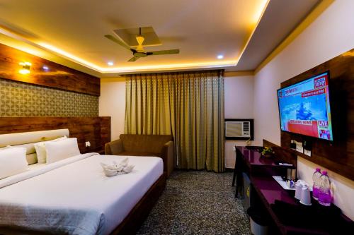 a hotel room with a bed and a flat screen tv at Xenious Hermitage Koshal, Puri in Puri