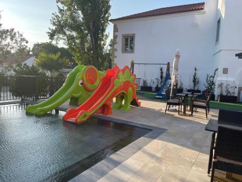 a slide in the middle of a swimming pool at Vila Gale Collection Tomar in Tomar