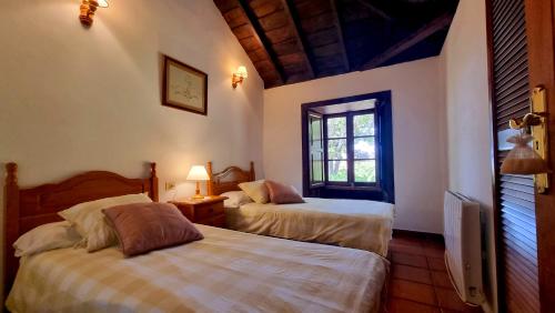 a bedroom with two beds and a window at El Jócamo in Puntagorda