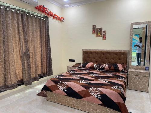 um quarto com uma cama e um espelho em Classic Villa em Pālghar