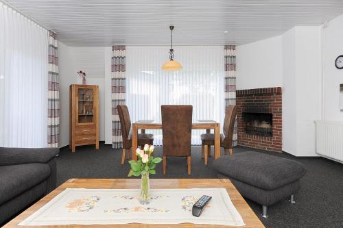 a living room with a table and chairs and a fireplace at Ferienhaus Am Tief in Neuharlingersiel