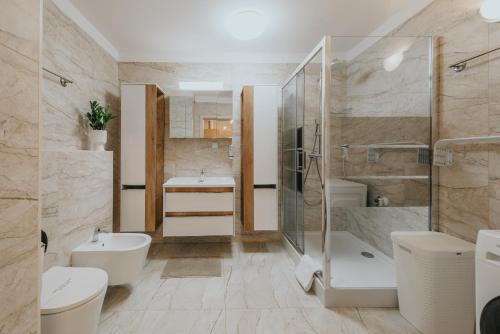 a bathroom with two sinks and a shower and a toilet at Mikro Aparty bezpłatny parking in Wrocław