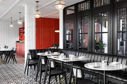 a restaurant with tables and chairs and red cabinets at Kimpton Hotel Fontenot by IHG in New Orleans