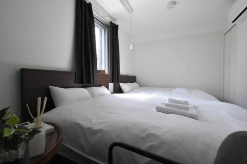 a bedroom with a large white bed with a window at 東駒形302 in Tokyo