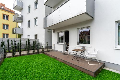 a backyard with a wooden deck and green grass at Apartment with garden Wolkowyska by Renters in Poznań