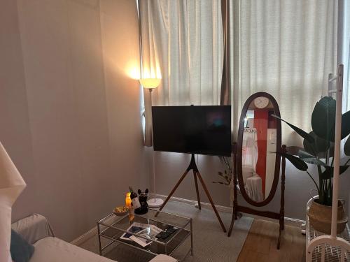 a living room with a tv and a mirror at DDUBLE Square in Daegu