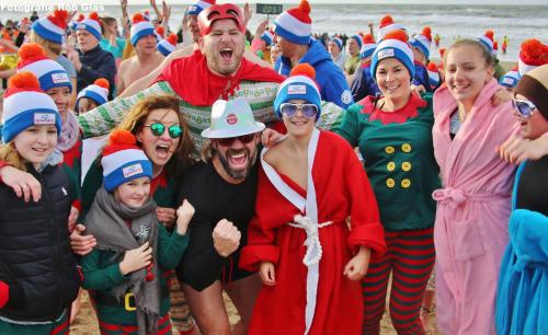 a group of people dressed in santa hats on the beach at Ferienhaus Glücklich am Meer 3 mit Wellnesszugang in Egmond aan Zee