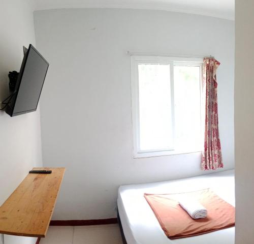 um quarto com uma cama e uma janela em Nyenyak Senayan Benhil em Jakarta
