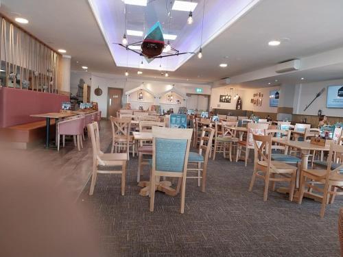een eetkamer met tafels en stoelen en een restaurant bij Julie'scaravan lettings in Kirby Cross