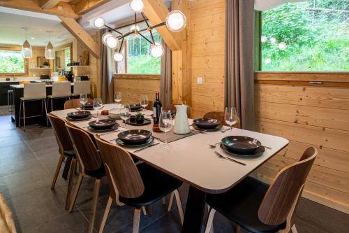 une salle à manger avec une table et des chaises blanches dans l'établissement Chalet Bonnabelle - Chamonix All Year, à Chamonix-Mont-Blanc