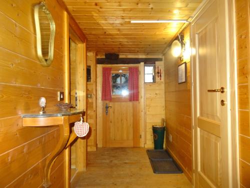 a hallway in a log cabin with a sink and a door at "CHALET dei FIORI" room & apartment in Bedretto