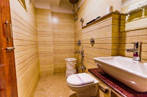 La salle de bains est pourvue d'un lavabo et de toilettes. dans l'établissement Xenious Hermitage Koshal, Puri, à Purî