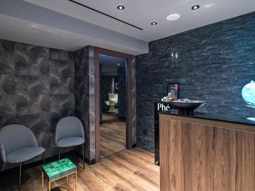 a bathroom with a sink and a counter with chairs at NYX Hotel Limassol in Limassol