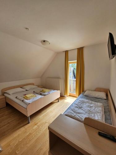 Duas camas num quarto com uma janela em Čandrova koča em Hocko Pohorje