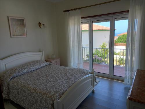 a bedroom with a bed and a view of a balcony at Villa Vitória in Nazaré