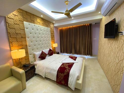 um quarto com uma cama e uma ventoinha de tecto em Hotel Valentino em Noākhāli