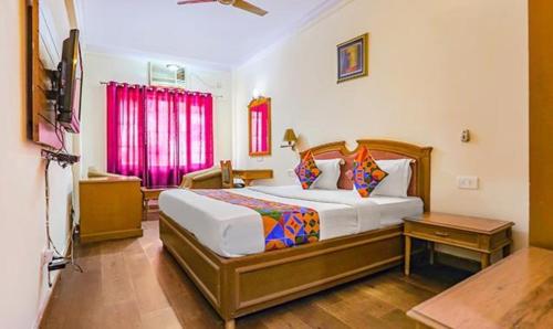 a bedroom with a large bed and a window at FabHotel Altus in Gurgaon