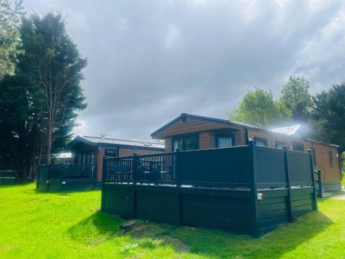 a house with a green fence in front of it at Pine Lodge with Hot Tub in York