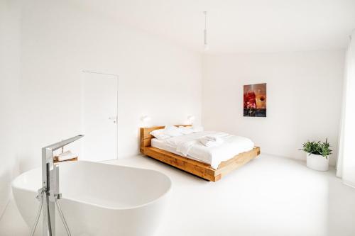 a white bedroom with a bed and a sink at REZAVY in Mikulov