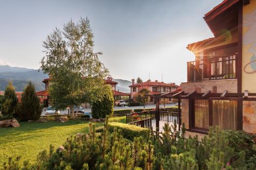 une maison avec un jardin en face d'un bâtiment dans l'établissement Ruskovets Thermal SPA & Ski Resort, à Bansko