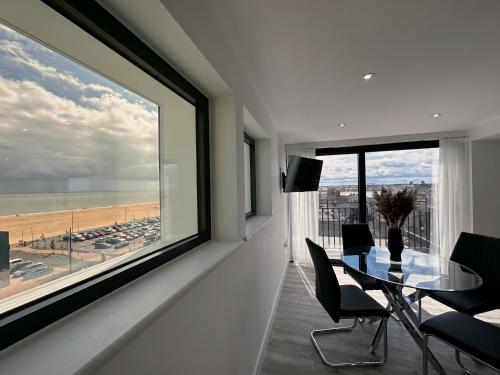 una sala da pranzo con tavolo e vista sulla spiaggia di The Atlantis - Tower Apartments a Great Yarmouth