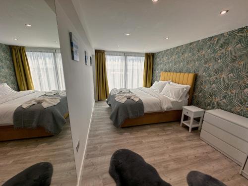 a bedroom with two beds and a chair in it at The Atlantis - Tower Apartments in Great Yarmouth