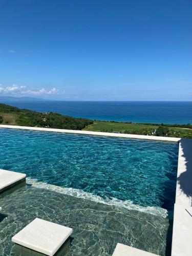 a swimming pool with a view of the ocean at Umarato Villa Sumba in Rua
