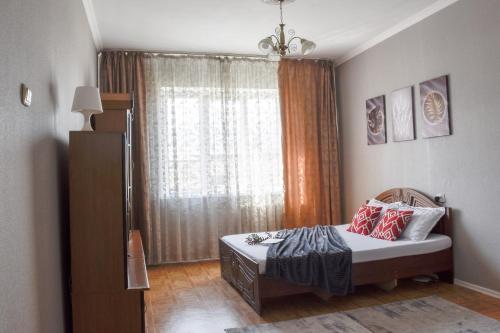 Kleines Zimmer mit einem Bett und einem Fenster in der Unterkunft YourHouse Микрорайон Жетысу-2, дом 69 in Almaty