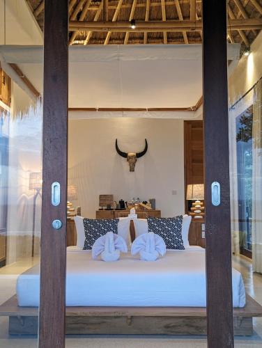a bedroom with a bed with two pillows on it at Umarato Villa Sumba in Rua