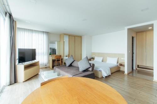 a hotel room with a bed and a couch at Karin hotel & Service apartment - SHA Extra Plus in Si Racha