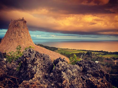 a view of a hill with a grass roof at Umarato Villa Sumba in Rua