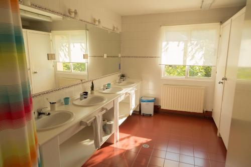 Baño con 2 lavabos y espejo en Amalurra Ecohotel & Retreat Center, en Artzentales
