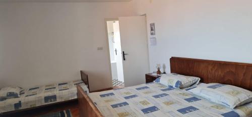 a bedroom with a bed with a wooden head board at Guesthouse Lidija in Sutivan
