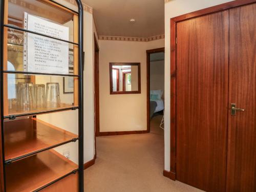 a hallway with a door and a room with glasses at Bide-a-While in Marnoch