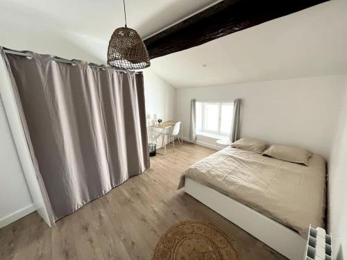 a bedroom with a bed with a curtain and a table at Luna - Moon 201 - Romans in Romans-sur-Isère