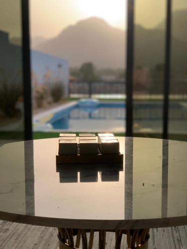 a glass table with chairs sitting on top of a pool at Great Escape for family and friends 4BR Villa with Private Pool and Sea View in Fujairah
