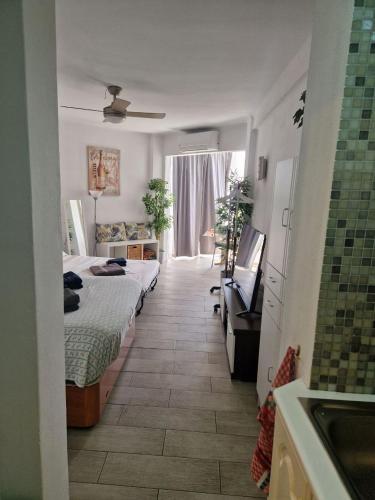 a bedroom with two beds and a television in it at Studio El Faro in Torrox Costa
