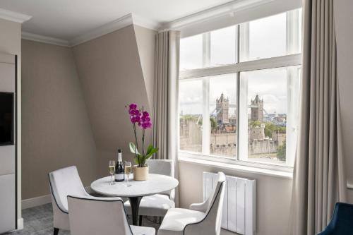a dining room with a table and chairs and a window at Tower Residences by Blue Orchid in London