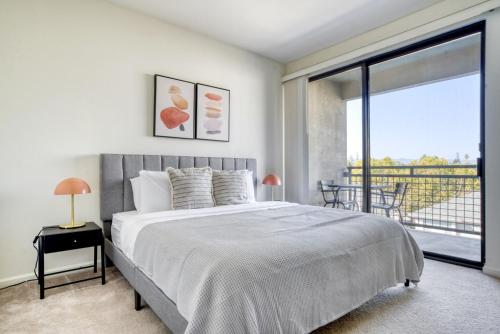 a bedroom with a large bed and a balcony at San Jose 1br w wd gym pool nr Caltrain SFO-1120 in San Jose