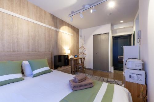 a bedroom with a large white bed and a television at REJ Reflet Ebisu in Tokyo