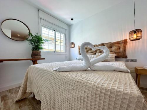 a bedroom with two swans made out of towels on a bed at Casa Elsa with Free Parking in Los Abrigos