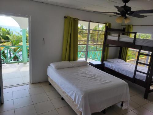 a bedroom with two bunk beds and a balcony at Ocean View in Big Corn Island