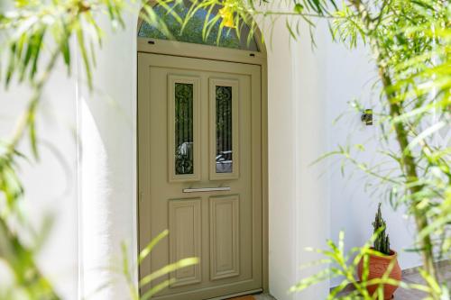 a wooden door in a white wall with plants at Kosnian City Suites in Kos